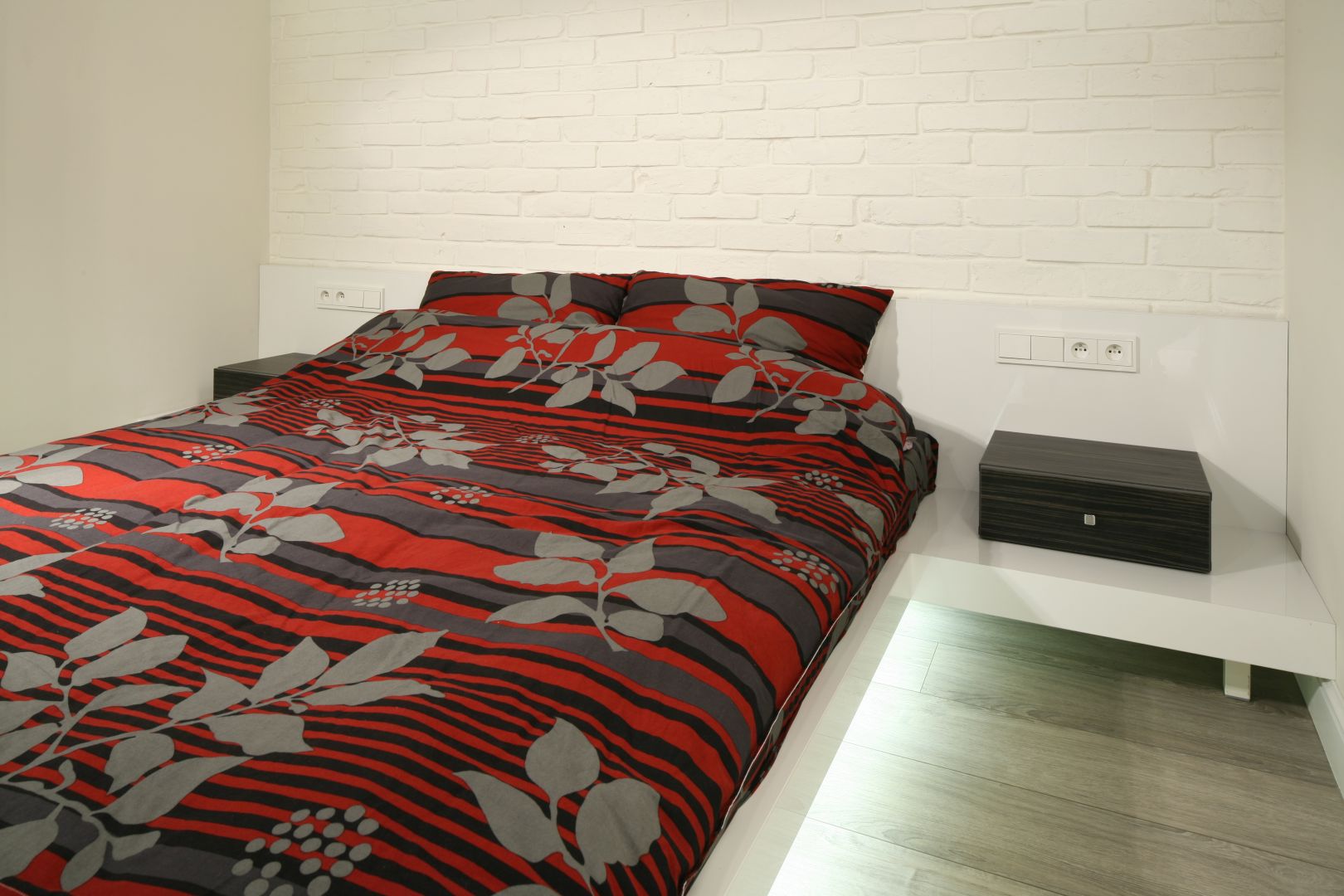 Sypialnia w minimalistycznym stylu. Podświetlone łóżko wygląda jakby unosiło się nad podłogą. Projekt: Dominik Respondek. Fot. Bartosz Jarosz 