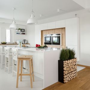 Biała kuchnia w minimalistycznym stylu. Elementy drewniane są tu minimalne, jednak znacząco wpływają na estetykę kuchni. Projekt: Małgorzata Błaszczak. Fot. Artur Krupa