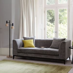 Szarą sofę warto ożywić poduszkami w soczystych, energetycznych kolorach. Do szarości doskonale pasują wszelkie odcienie barwy żółtej. Fot. Romo
