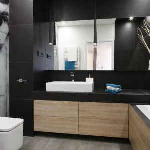 Industrialne wnętrza mają bardzo wyrazisty charakter. W tej łazience połączenie czerni i betonu sprawiło, że aranżacja jest bardzo męska. Ociepla ją drewno. Projekt: Łukasz Szadujko. Fot. Bartosz Jarosz