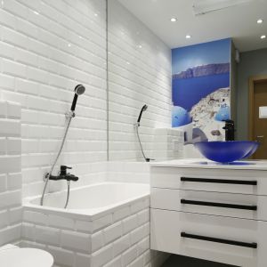 Ściany w łazience to doskonałe miejsce na wyeksponowanie zdjęć z egzotycznych podróży. Krajobraz słonecznego Santorini doskonale wpisuje się w kąpielowy klimat łazienki. Projekt: Ewa Para. Fot. Bartosz Jarosz