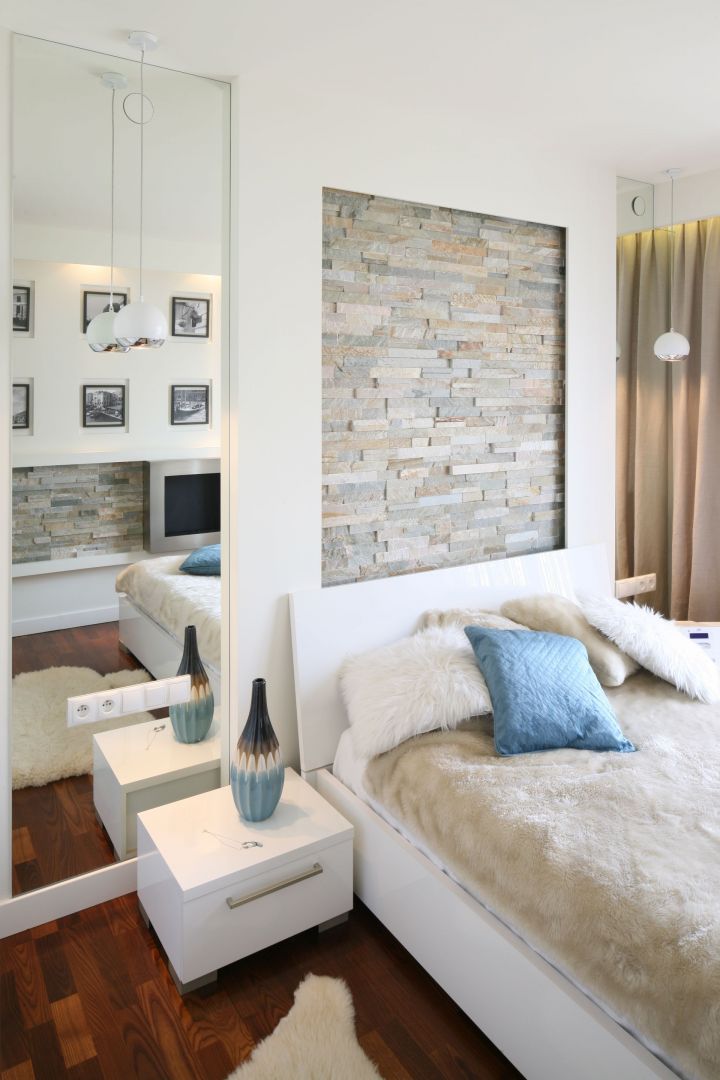 Kamień jest bardzo modnym materiałem. Można go stosować nie tylko w salonie, ale również na ścianie w sypialni. Projekt Małgorzata Mazur. Fot. Bartosz Jarosz