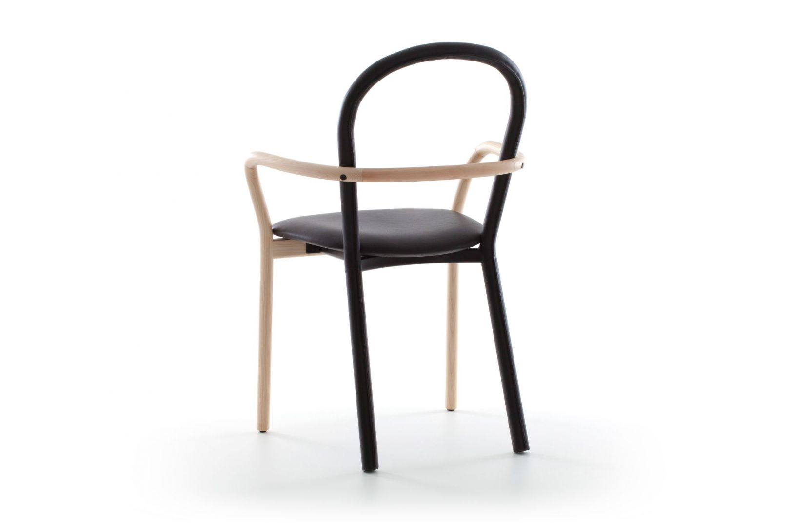 Prosta forma, czarna skóra i kontrastowe połączenie drewna. Krzesło Gentle łączy archetypiczny kształt z ponadczasową elegancją w stylu retro. Fot. Porro
