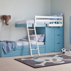 Piętrowe łóżka również mogą zaskakiwać formą. Dolna leżanka wysunięta w bok dała miejsce dla niewielkiej, ale pojemnej szafy na ubrania dziecięce. Fot. Cuckooland
