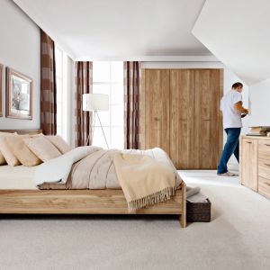 Meble do sypialni Raflo charakteryzują się delikatnym, jasnym odcieniem drewna i zdobionymi bokami brył. Fot. Black Red White