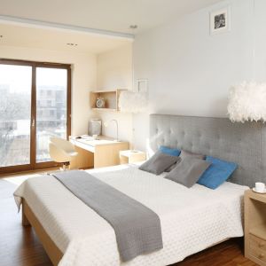 Drewniane łóżko z szarym zagłówkiem prezentuje się bardzo przytulnie. Można je ożywić kolorowymi dodatkami. Projekt: Marta Kruk. Fot. Bartosz Jarosz