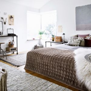 W skandynawskiej sypialni istotne są tkaniny. Puszyste poduchy, lniane koce czy materiały z modnymi wzorami. Fot. Broste Copenhagen