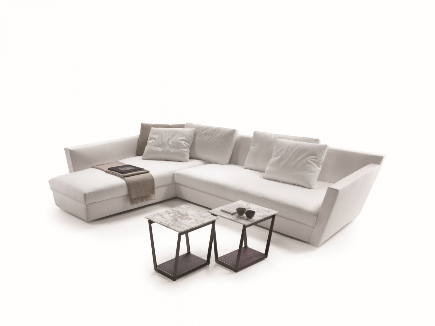 Sofa Adagio wyróżnia się geometryczną formą. Uroku dodają jej poduszki, utrzymane w podobnej tonacji kolorystycznej. Fot. Flexform 