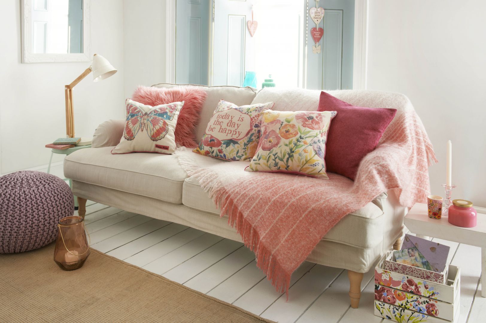 Aby sofa w salonie prezentowała się przytulniej, warto udekorować ją kolorowymi poduszkami. Fot. Matalan