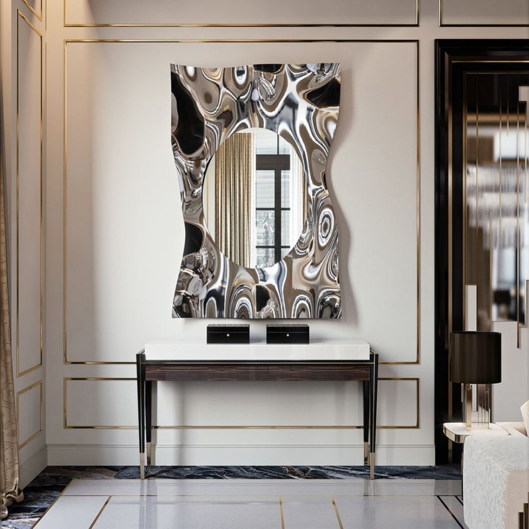 Lustro Impact Specchio z ramą przypominającą zmąconą taflę wody wykonaną z błyszczącej stali. Fot. Galeria Mebli Heban
