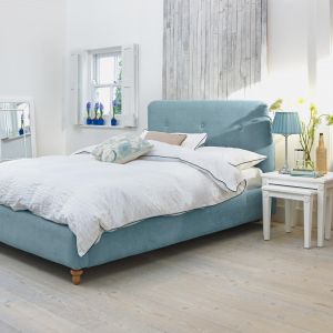 Niebieska tkanina łóżka nada wnętrzu sypialni świeży styl. Fot. Agros