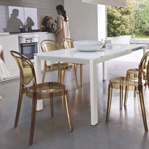 Biały stół o nowoczesnej formie doskonale komponuje się z krzesłami wykonanymi z tworzywa sztucznego. Fot. Kler