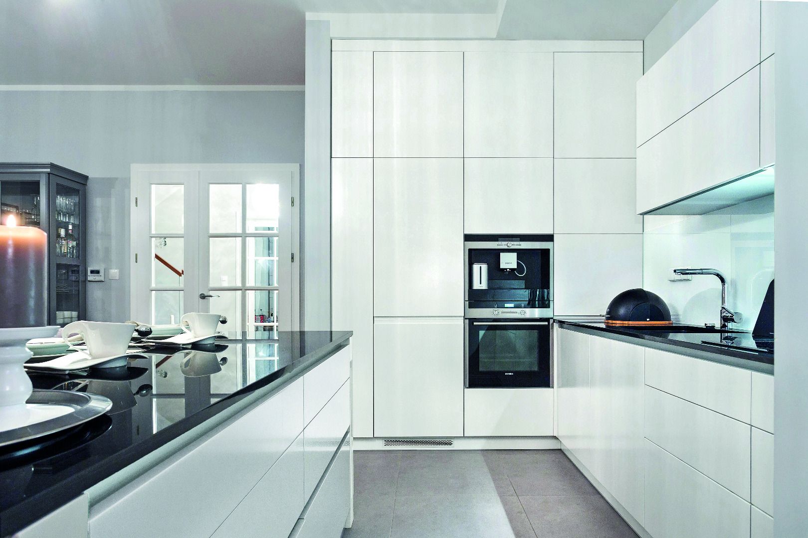 Fronty bezuchwytowe cieszą się ogromną popularnością wśród projektantów przestrzeni kuchennych. Są bardzo praktyczne, wygodne i pomagają zadbać o czystość podczas kuchennych eksperymentów.  Fot. Studio Wach/Max Kuchnie 
