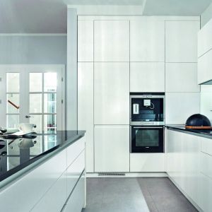 Fronty bezuchwytowe cieszą się ogromną popularnością wśród projektantów przestrzeni kuchennych. Są bardzo praktyczne, wygodne i pomagają zadbać o czystość podczas kuchennych eksperymentów.  Fot. Studio Wach/Max Kuchnie 