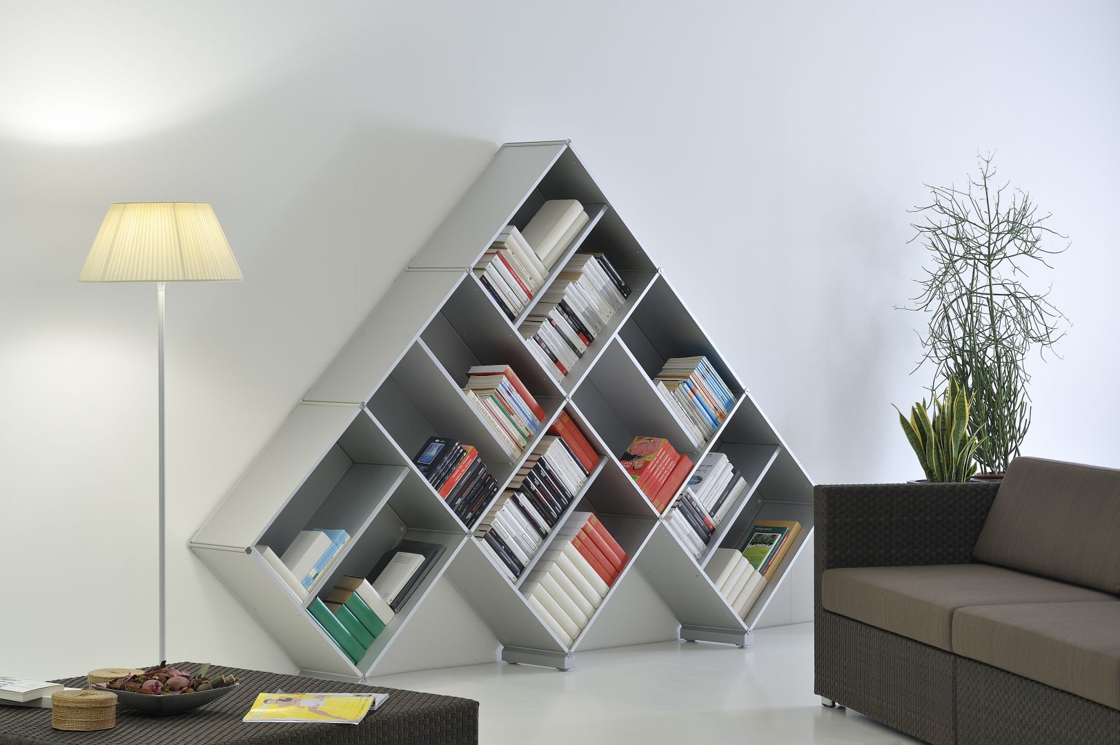 Półki w kształcie piramidy to prawdziwa ozdoba salonu. Książki są przechowywanie w ciekawy sposób. Fot. Piarotto