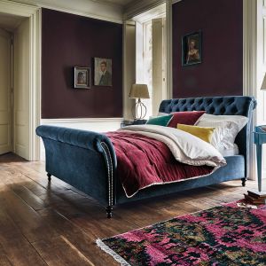 Niebieski to bardzo stylowy kolor. Szczególnie pięknie prezentuje się w formie tapicerowanego łóżka w stylu glamour. Fot. Feather and Black