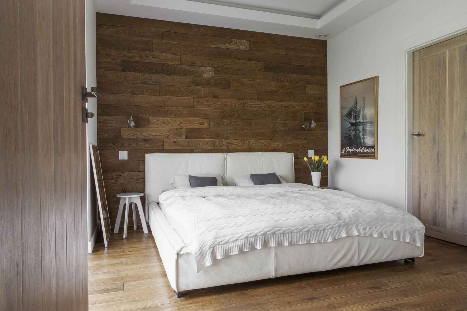 Drewno na ścianie za łóżkiem nadaje aranżacji sypialni rustykalny ton. Projekt: Anna Nowak-Paziewska. Fot. Emi Karpowicz