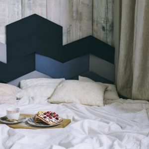 Sypialnia z geometrycznym zagłówkiem w różnych odcieniach koloru niebieskiego. Fot. Interiors Design Blog 