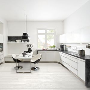 Biel kuchni podkreślają czarne elementy krzeseł i grafitowe blaty. Fot. Nolte