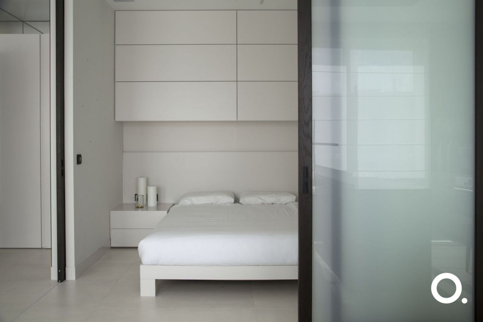 Dzięki drzwiom przesuwnym skomponowano ruchomą ścianę, która oddziela minimalistyczną, surową sypialnię od części dziennej mieszkania. Fot. Studio O.