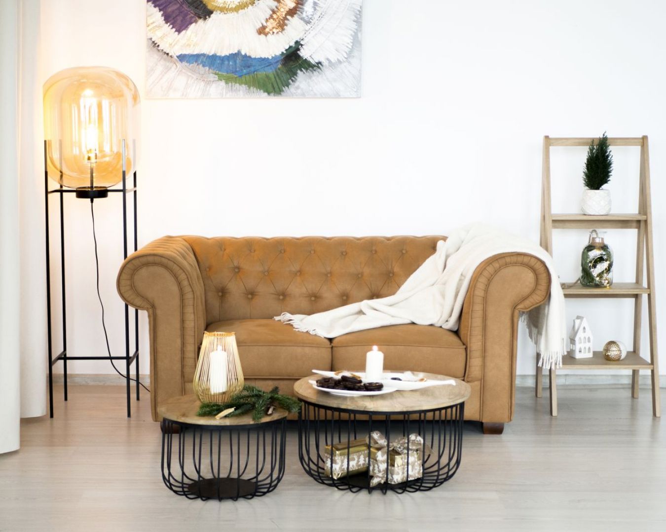Sofa typu chesterfield zestawiona z kawowymi stolikami z drewna dobrze sprawdzi się w typowo domowym salonie. Fot. Make Home
