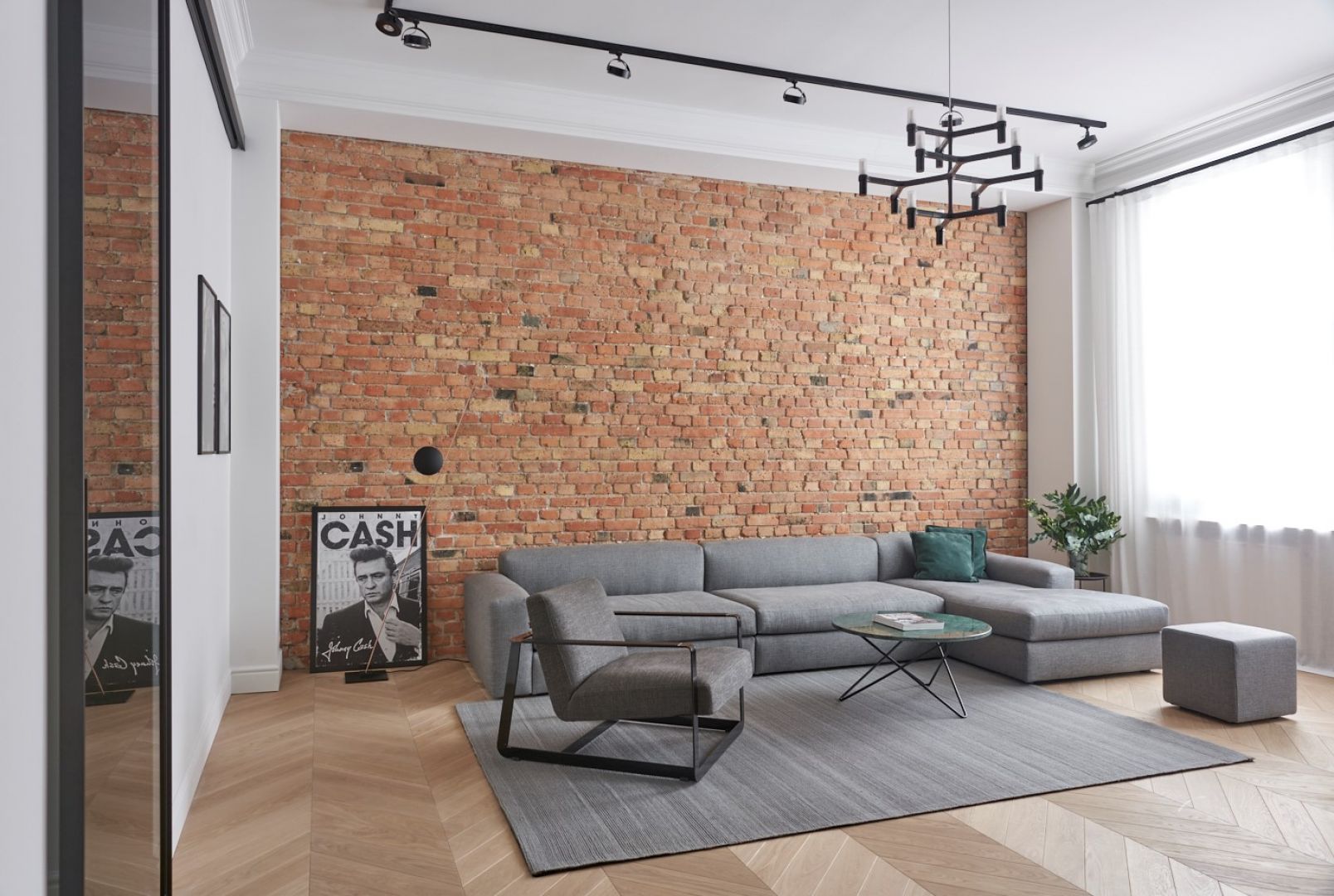 Szarość pasuje do stylu loftowego - sofa doskonale prezentuje się na tle ceglanej ściany. Realizacja Zendesign/Studio Forma 96