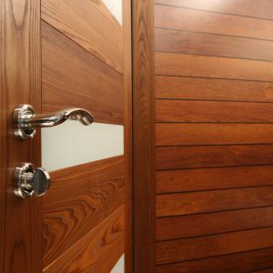 Drzwi prowadzące do łazienki dla gości stanowią kolorystyczne uzupełnienie drewnianych wykończeń pomieszczenia. Fot. Bartosz Jarosz