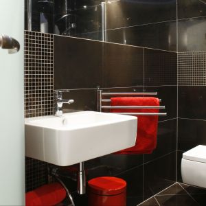 Czerwone dodatki oraz powiekszajace przestrzeń lustra to idealne uzupełnienie czerni w łazience przy sypialni. Fot. Bartosz Jarosz