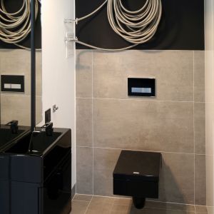 Szarości w połączeniu z czernią czynią tę surową, minimalistyczną przestrzeń łazienki na parterze bardzo elegancką. Fot. Bartosz Jarosz