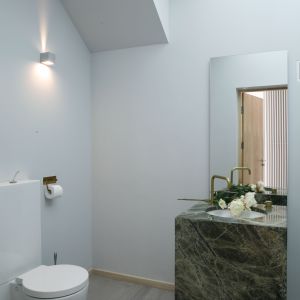 Świetlik w suficie toalety jest jednocześnie elementem szklanej podłogi na piętrze. Wpisuje się w nowoczesne rozwiązania zastosowane w całym domu. Fot. Bartosz Jarosz