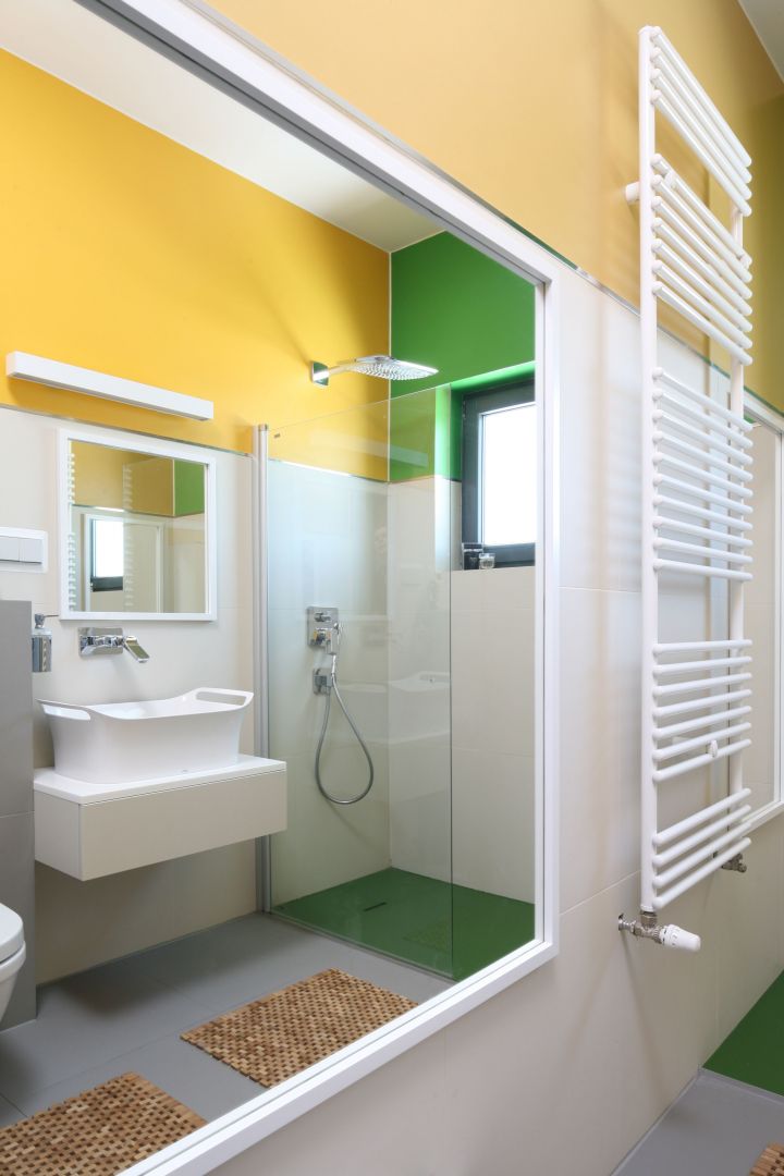 Ogromne lustro w prostej, białej ramie optycznie powiększa przestrzeń łazienki. Jego mniejsza wersja wisi dokładnie naprzeciwko – na ścianie nad umywalką. Fot. Bartosz Jarosz