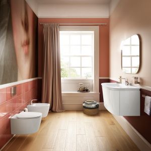 Kolekcja Dea marki Ideal Standard oraz eleganckie dekoracje w postaci obrazu i zasłony okna dodają łazience domowego klimatu. Fot. Ideal Standard