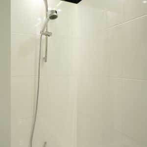 Parawan w postaci ścianki działowej oraz zestaw natryskowy z przesuwaną rączką pozwalają korzystać z wanny jak z prysznica.  Fot. Bartosz Jarosz