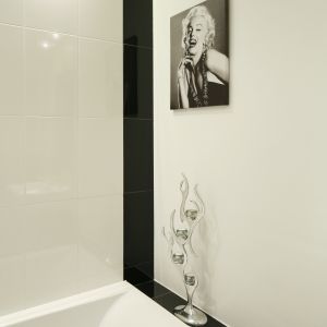 Zdjęcia Marilyn Monroe jako dekoracja to był pomysł pani domu; jedno z nich znalazło się w salonie, drugie -w łazience. Powieszone nad wanną (Cersanit) dodaje szyku strefie kąpielowej. Świecznik z katalogu Kare Design. Fot. Bartosz Jarosz