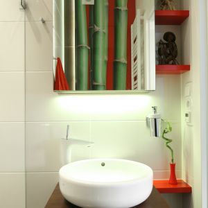Dzięki czerwonym akcentom, aranżacja łazienki gościnnej ma wyrazisty charakter. W tym kolorze są m.in. półeczki obok umywalki przeznaczone na dekoracje. Fot. Bartosz Jarosz