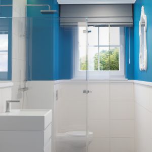 Białe płytki i ciemny niebieski na ścianach, a na suficie – błękit. Taka kolorystyka sprawiła, że łazienka ma wyrazisty styl. Fot. Dekoral

