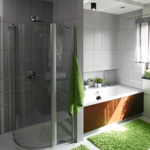 Wnętrze spełnia potrzeby wszystkich domowników: w łazience dla rodziny znajdują się zarówno prysznic i wanna. Sprzęty umieszczone obok siebie siebie rozdziela ścianka, która stworzyła narożnik dla kabiny prysznicowej. Projekt: Anna Gruner. Fot. Bartosz Jarosz