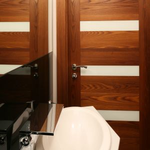 Drewniane drzwi idealnie wpisują się w styl małej toalety w drewnie. Proj. Chantal Springer. Fot. Bartosz Jarosz