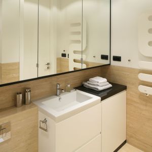 Szafki z lustrzanymi frontami dodatkowo optycznie powiększają jasną łazienkę. Proj. Anna Maria Sokołowska. Fot. Bartosz Jarosz