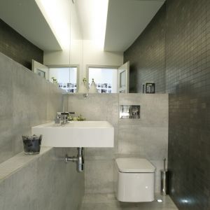 Toaleta dla gości wykończona płytkami w odcieniu cementowej szarości. Proj. Piotr Wełniak. Fot. Monika Filipiuk-Obałek
