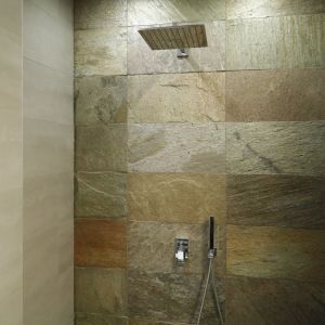 Prysznic ma formę otwartą, dzięki czemu piękny kamień naturalny na ścianie za prysznicem zdobi całe pomieszczenie. Proj. Piotr Stanisz. Fot. Bartosz Jarosz