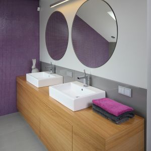 Duża szafka oraz oddzielne umywalki i lustra dla pani oraz pana domu tworzą bardzo wygodną strefę toaletową. Ścianę nad blatem chroni szkło lakierowane. Fot. Bartosz Jarosz.