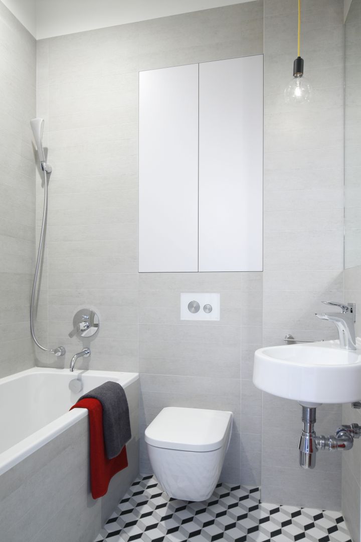 Szara łazienka dla gości ma oryginalną podłogę z płytek ze wzorem 3D. Nietypowe nadruki to dynamiczny akcent w mocno stonowanej aranżacji. Fot. Bartosz Jarosz