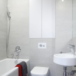 Szara łazienka dla gości ma oryginalną podłogę z płytek ze wzorem 3D. Nietypowe nadruki to dynamiczny akcent w mocno stonowanej aranżacji. Fot. Bartosz Jarosz