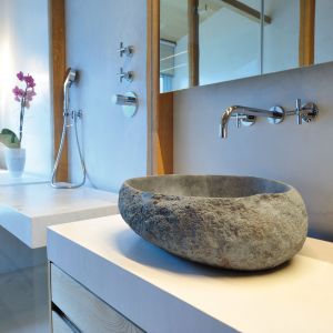 Kamienna misa sprawia, że domownicy korzystając z łazienki mogą się poczuć jak na łonie natury. Projekt: Coblonal Arquitectura. Fot. Coblonal Arquitectura.