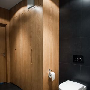 Wysoka zabudowa przy drzwiach do łazienki pozwala pomieścić wszystko, co niezbędne. Projekt: Michał i Marta Raca. Fot. Adam Ościłowski