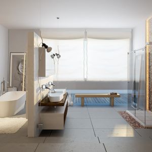 Salon kąpielowy urządzony w jasnej kolorystyce z dyskretnie oddzieloną strefą kąpieli z wolno stojącą wanną. Fot. Moma Design