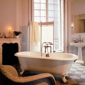Salon kąpielowy urządzony w klasycznym stylu z piękną wanną wolno stojącą na zdobnych nogach i armaturą w stylu retro marki Axor z kolekcji Montreaux. Fot. Hansgrohe