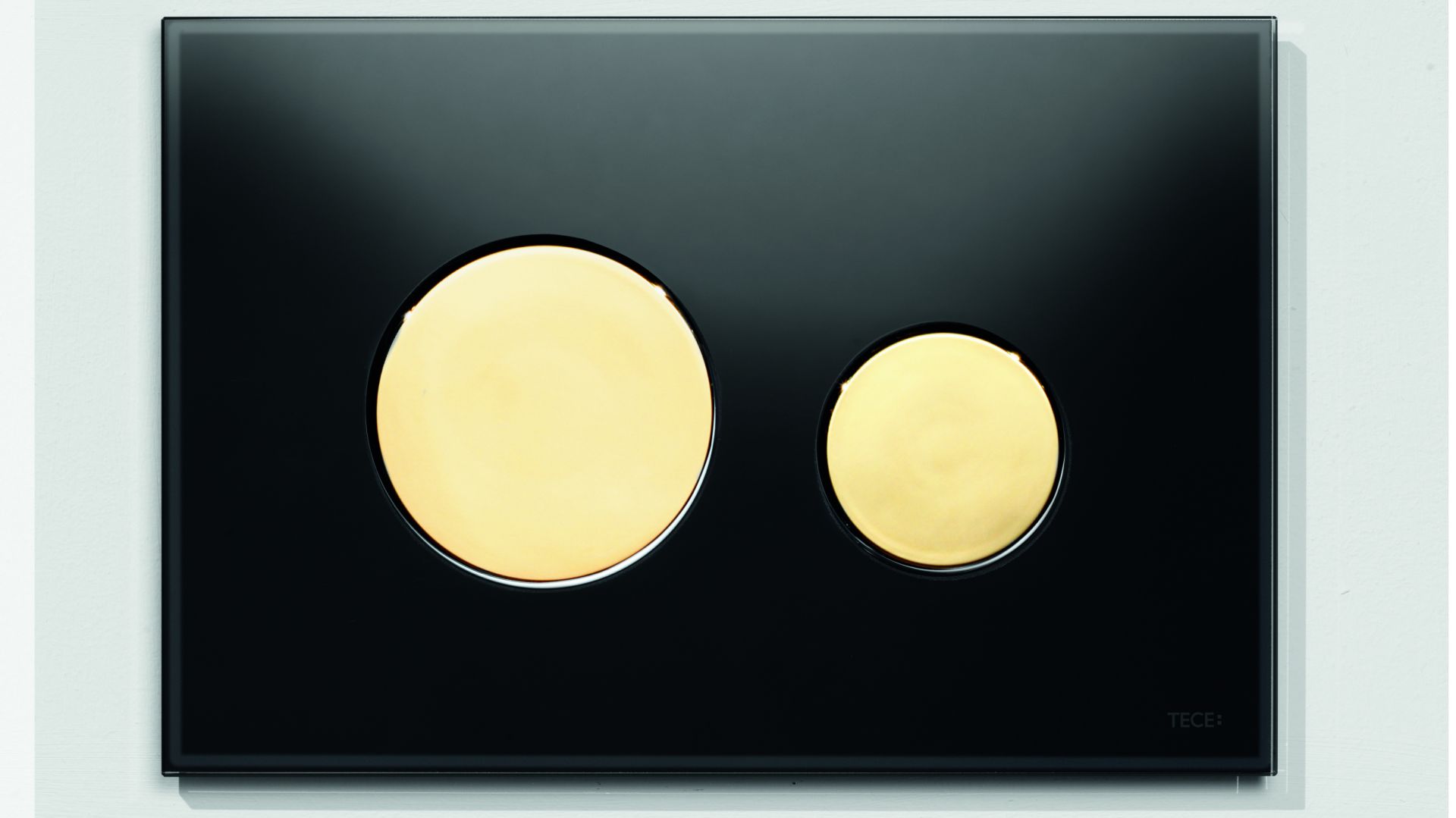 Złoto w łazience: przyciski spłukujące jako efektowny detal
