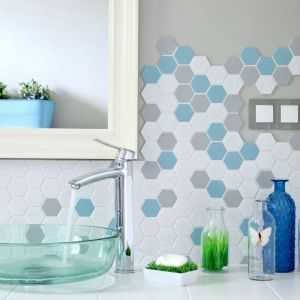 Mozaika Heksagon Duży w różnych kolorach: białym, szarym i miętowym zdobi ścianę nad umywalką. Fot. Raw Decor